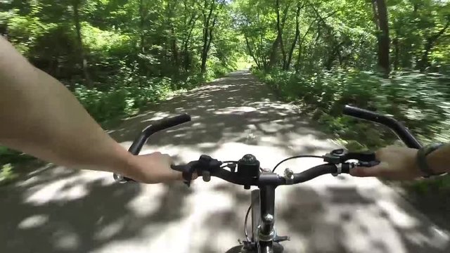 Point of view shot of boy biking down a nature hill fast coasting.
