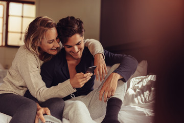 Relaxed couple looking at mobile phone