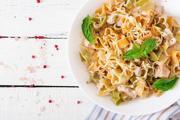 Creamy pasta with chicken and eggplant  served in deep plate. Italian food. Top view. Flat lay.