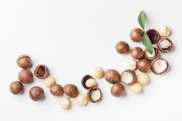 Heap of macadamia nuts on white table top view. - obrazy, fototapety, plakaty