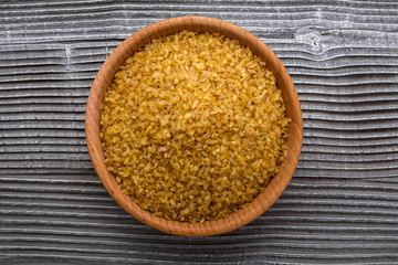 raw bulgur on a rustic wooden background