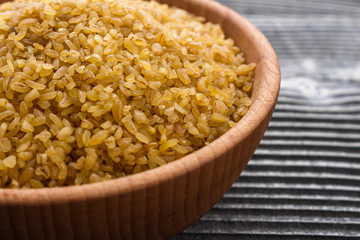 raw bulgur on a rustic wooden background