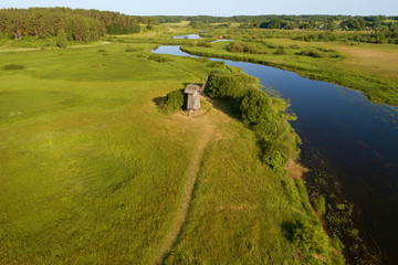 The old windmill and the Sorot River on a warm June morning. Pushkin Mountains, Russia