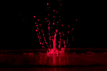Red paint, ink splash on black background