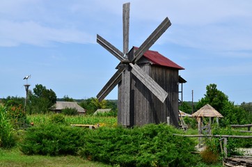 Fototapeta na wymiar An old windmill, a decorative stork in a nest