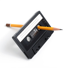 Using pencil to spin mangled cassette tape isolated on white background.