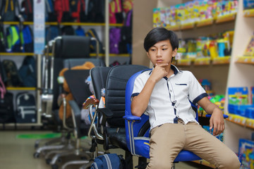 Portrait portrait boy schoolboy buy shop backpack asian sit one supplies office chair elementary school student pushing shopping cart ready