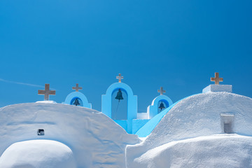 Cycladic greek orthodox church on Paros island, Greece. White crosses against blue sea and sky