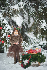 Fairy tale girl. Portrait a little girl in a deer dress with a painted face in the winter forest....