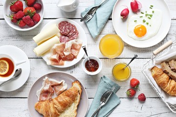 Breakfast food table. Brunch set, meal variety with fried egg, croissants, granola and fresh...