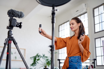 Woman beauty vlogger marketing product to camera