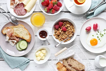 Fotobehang Breakfast food table. Brunch set, meal variety with fried egg, croissants, granola and fresh strawberry. Overhead view © losangela