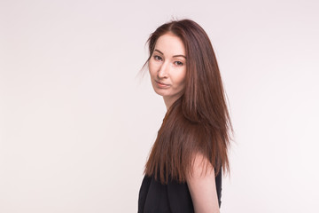 Fototapeta premium Portrait of a beautiful young asian woman with dark hair on white background with copy space