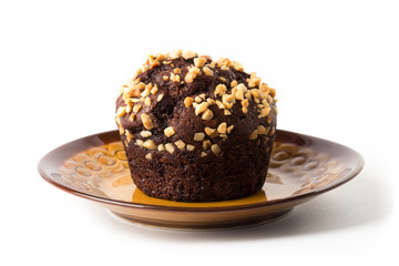 Chocolate muffin on a brown plate, isolated on white background
