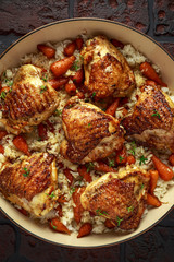Free range chicken thighs with rice and honey glazed chantenay carrots in pan
