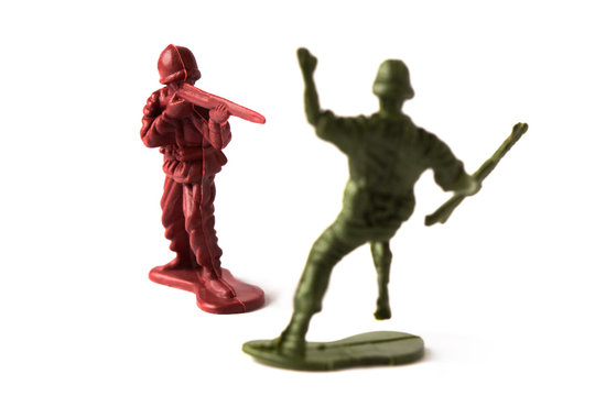 Toy soldier shooting an enemy in a toy battle, isolated on white background