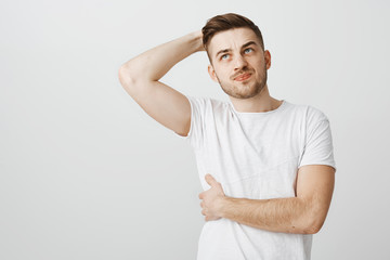 Attractive unshaven sportsman feeling pain in chest touching bone, smirking from painful feeling...