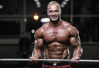Obraz na płótnie Canvas Handsome strong bodybuilder athletic men pumping up muscles with dumbbells