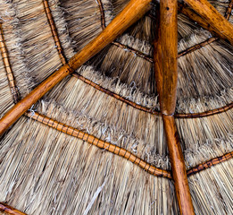 View from below of a thatched tropical beach parasol umbrella made naturally from wood and straw in a resort in Mexico in the carribean © F-Stop Boy