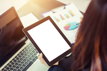 hand Businesswoman using tablet tablet blank screen display in her office ,soft light with vintage filter.