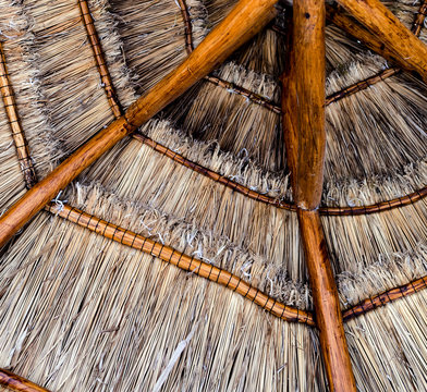 View from below of a thatched tropical beach parasol umbrella made naturally from wood and straw in a resort in Mexico in the carribean