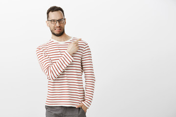 Indoor shot of disgusted displeased funny male model with bristle in black eyewear, sticking out...
