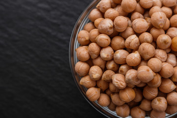 uncooked chickpeas on a dark stone background