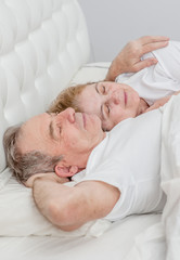 Fototapeta na wymiar elderly couple sleeping together on the bed