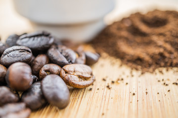 close-up coffee beans with cup on wooden rustic board