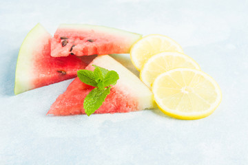 Watermelon. lemon and mint on blue background, ingredients for nonalcoholic mijito or smoothie