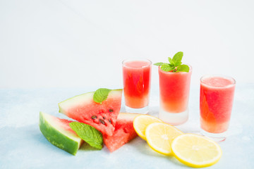 Fresh watermelon drink with lemon and mint in three glasses