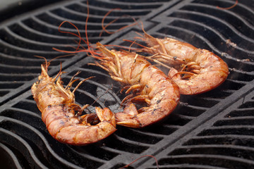 three prawns are cooked on the grill
