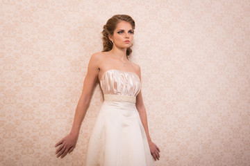 Fototapeta na wymiar Bride in a wedding dress with hair and makeup in vintage interiors.