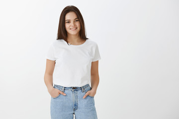 Fashion is my life. Stylish happy young female model in jeans and casual t-shirt, holding hands in...