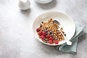 Granola. Healthy breakfast with granola and seasonal berries. Gray concrete background