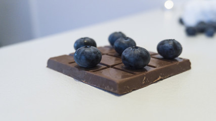Chocolate, blueberries and cranberries. Berry background and a cup of coffee.