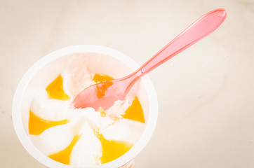 fruit ice cream in a glass and spoon/fruit ice cream in glass and pink spoon on a white background, top view