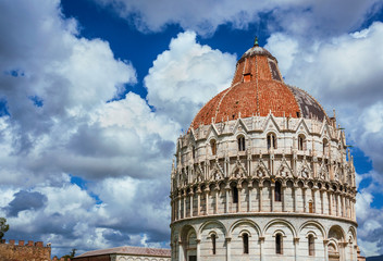 Pisa Baptistry medieval dome with clouds and city ancient walls