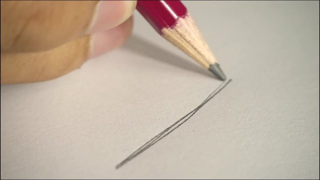 Artists hands drawing wooden pencil writes on paper