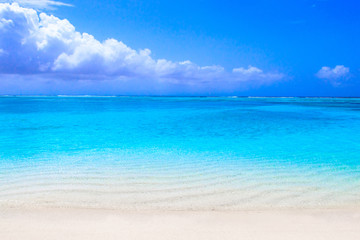 Fototapeta na wymiar Lonely sandy beach with turquoise ocean and blue sky