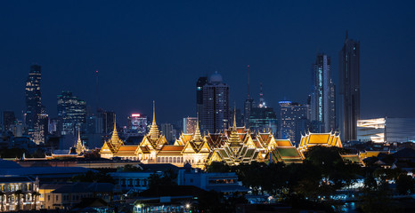 Grand palace and Wat Phra Kaew surround by modern buildings, in Bangkok city Thailand