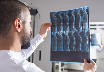 Doctor analysing X-ray image in consulting room