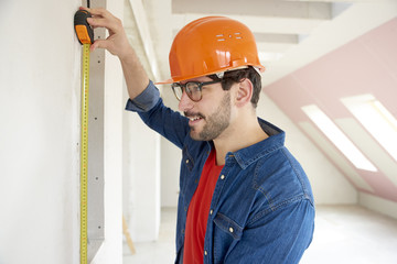 Repairman using measuring tape