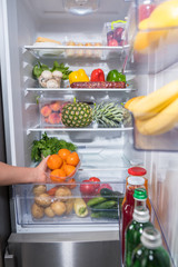 Person taking fresh oranges from fridge © kolotype