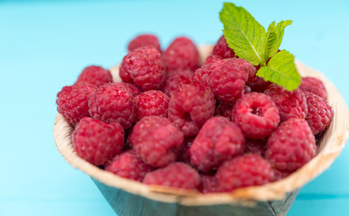 Bowl of juicy raspberries in close up view
