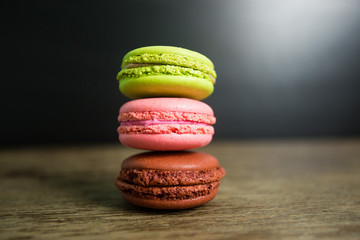 Fototapeta na wymiar Cake macaron or macaroon on wooden table with black background, sweet and colorful dessert