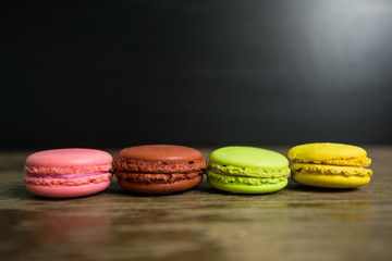 Obraz na płótnie Canvas Cake macaron or macaroon on wooden table with black background, sweet and colorful dessert