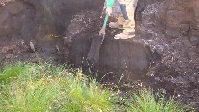 Turf cutting peat at a bog in Ireland