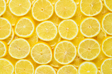 A slices of fresh juicy yellow lemons.  Texture background, pattern.