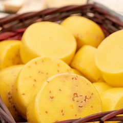 Cheese in basket. Head of delicious cheese.